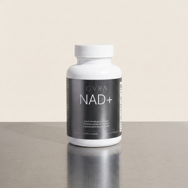 OVRA NAD+ bottle on brushed steel, bone-white studio background