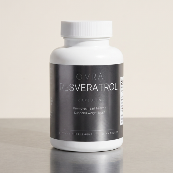 OVRA Resveratrol bottle on brushed steel, bone-white studio background